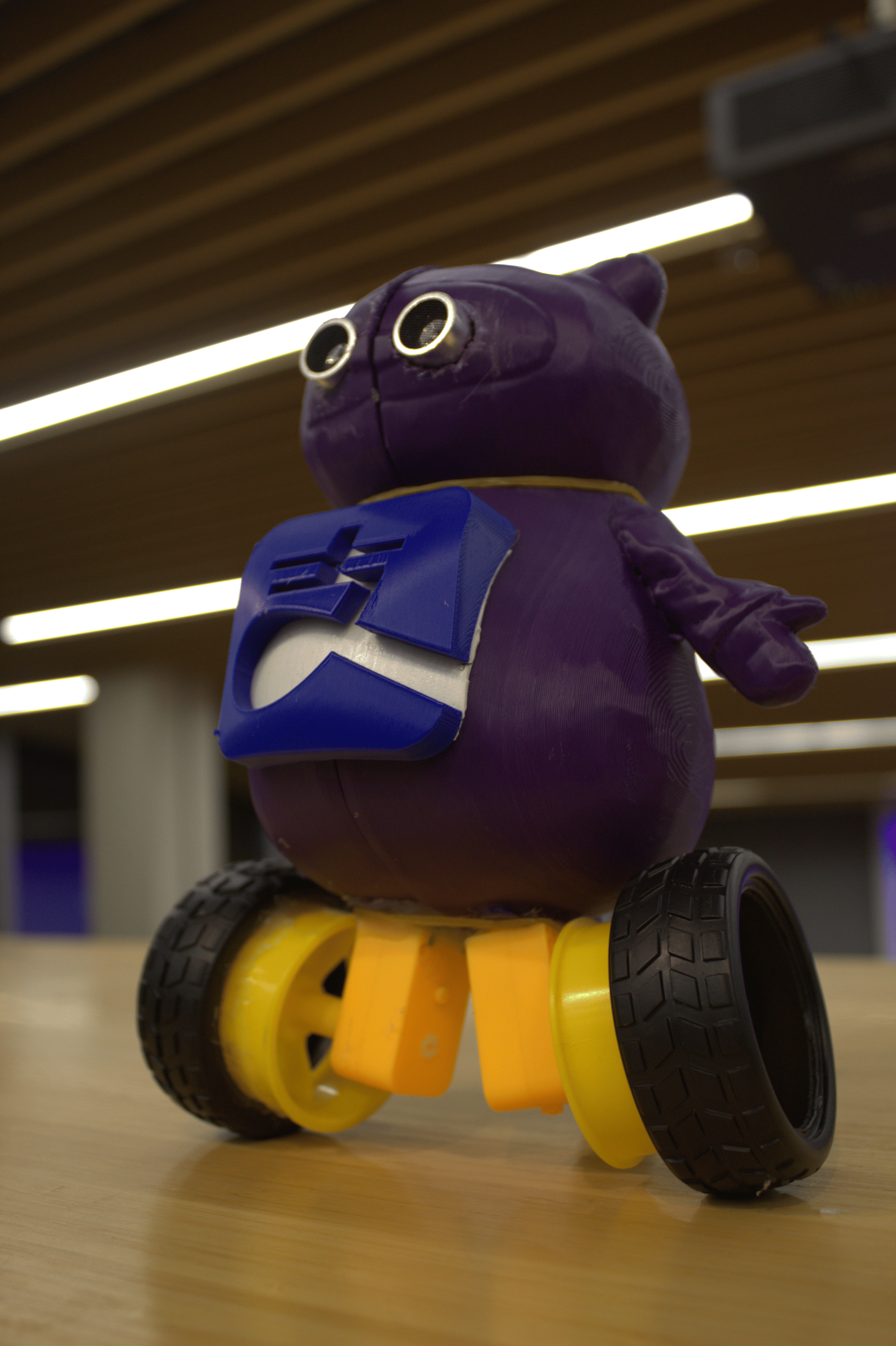 Three-quarter photo of the purple AliPayBot prototype, showing its body and yellow wheels.