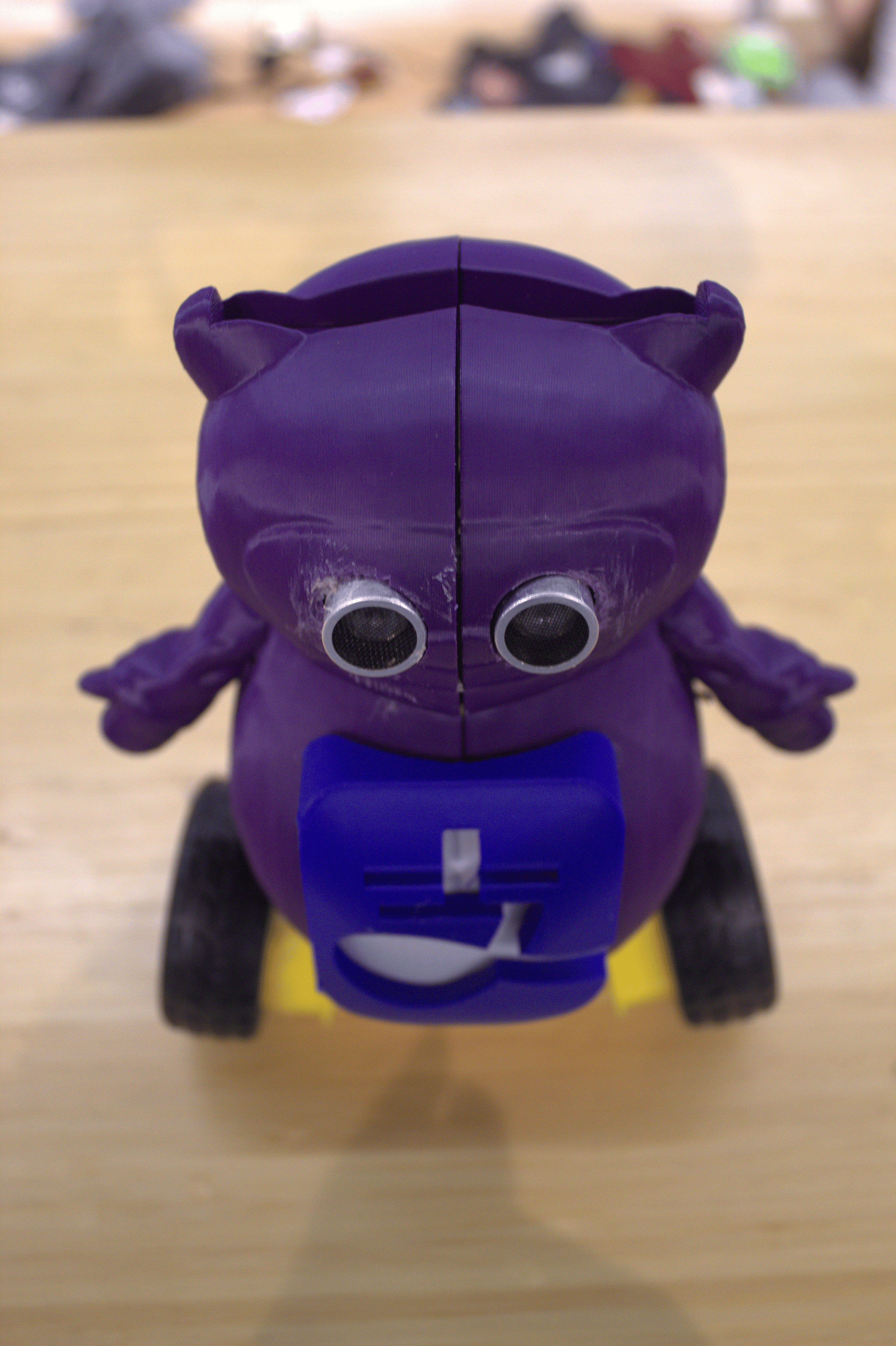 Front photo of the purple AliPayBot prototype with its blue panel and yellow wheels.