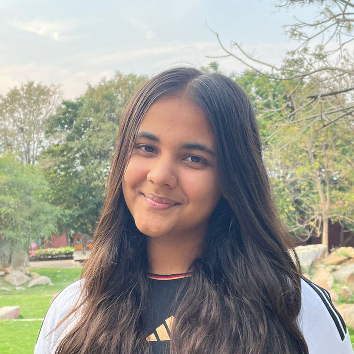 Outdoor portrait of a young woman wearing a black shirt.